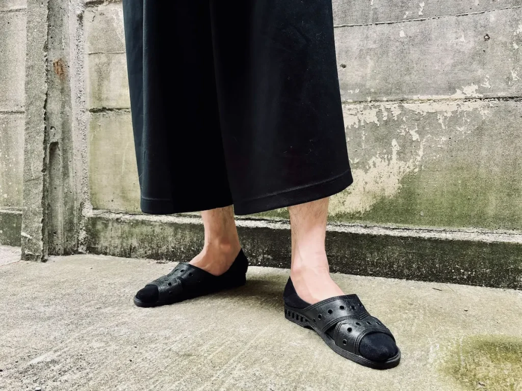 黒いサンダルを履いて外にいる男性